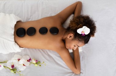 African kadın yalan Ile Spa Stones üzerinde arka