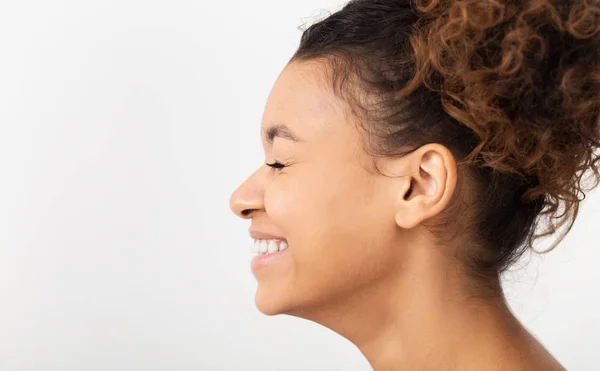 Afroamerikanerin lacht mit geschlossenen Augen, Seitenansicht — Stockfoto