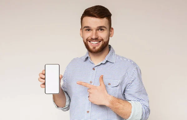 Smiling millennial man holding latest slim cellphone — Stock Photo, Image