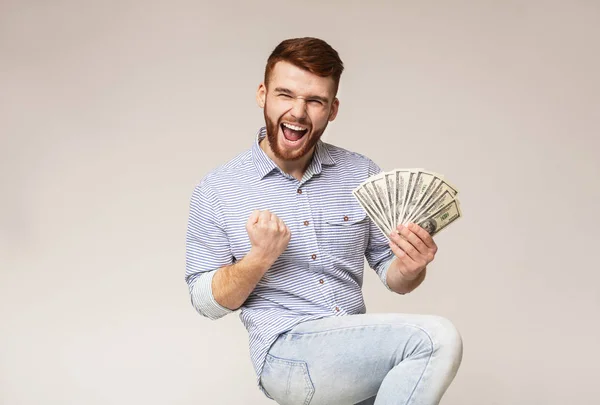 Jovem bonito cara feliz por ter fã de dólares — Fotografia de Stock