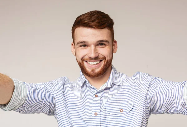 Fröhlicher Mann hält Kamera und macht Selfie — Stockfoto