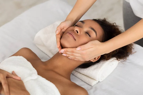 Spa-behandling. Afrikansk-amerikansk flicka få Face massage — Stockfoto
