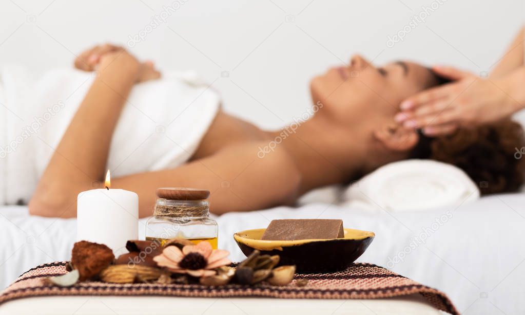 Aroma Spa. Afro Woman Enjoying Facial Massage In Luxury Spa