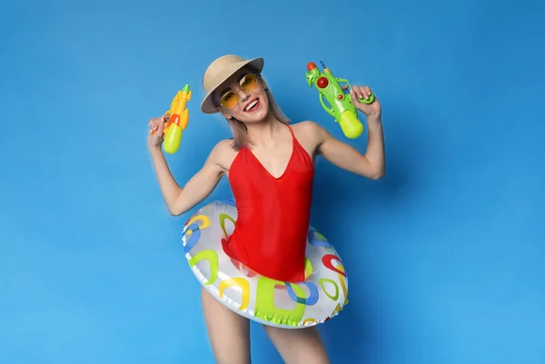 Грайлива блондинка в купальнику готова до розваги з водяними пістолетами — стокове фото