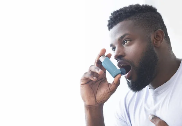 Junger Mann benutzt Asthma-Inhalator zu Hause — Stockfoto