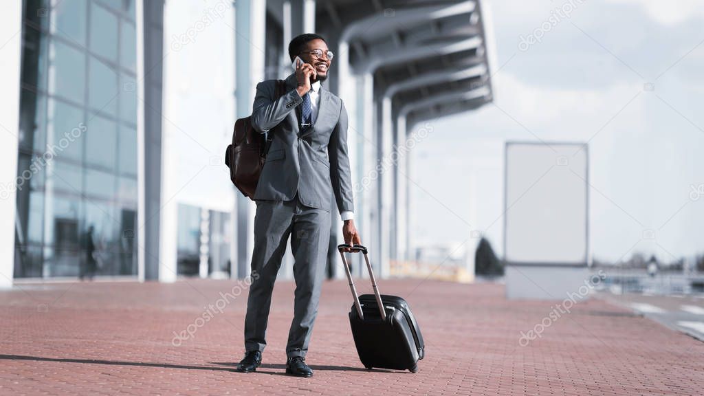 Arriving to Airport. Afro Businessman Talking on Phone
