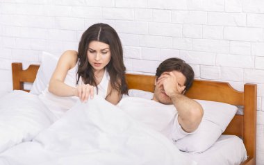 Kadın yatakta battaniyenin altında seyir ile erektil disfonksiyon