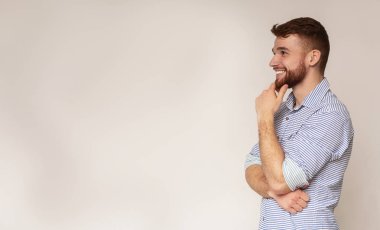 Genç gülümseyen adam düşünme ve boş alana bakarak
