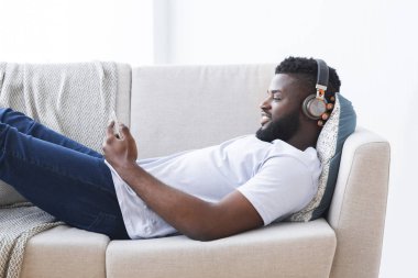 Akıllı telefonda video izleyen Afrikalı adam, mobil uygulama kullanıyor