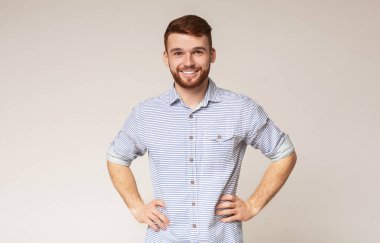 Kalçalarında elleri olan gülümseyen adamın portresi