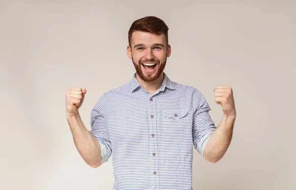 Cheerful guy showing his biceps and smiling — Stock Photo, Image