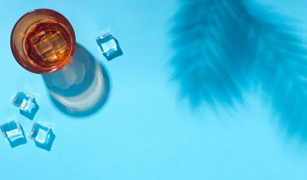 Tropischer erfrischender Cocktail mit Eiswürfeln auf blauem Hintergrund — Stockfoto
