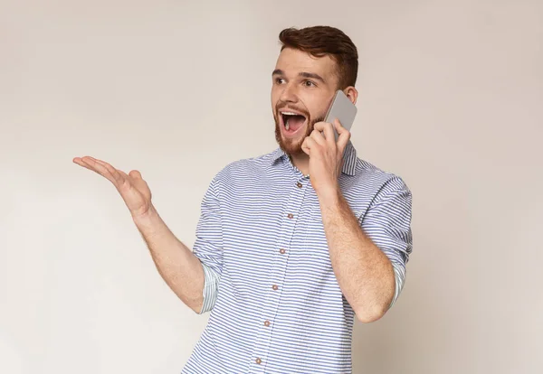 Handsome guy happy to hear good news talking on phone — Stock Photo, Image