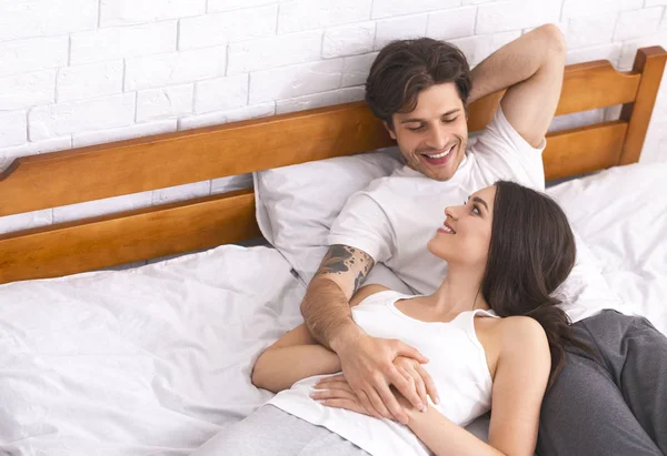 Positiva coppia millenaria comunicante in camera da letto, spazio libero — Foto Stock