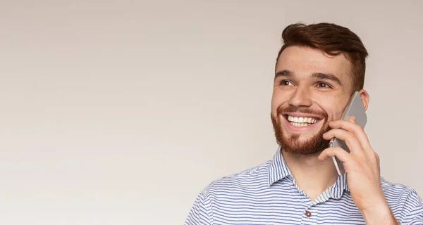 Portret van jonge man praten op mobiele telefoon en glimlachend — Stockfoto