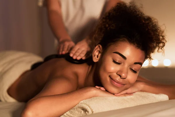 Tratamento corporal. Relaxado menina desfrutando de massagem quente — Fotografia de Stock