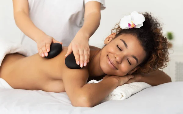 Relaxing Massage. Afro Woman Enjoying Stones Shoulder Massage — Stock Photo, Image
