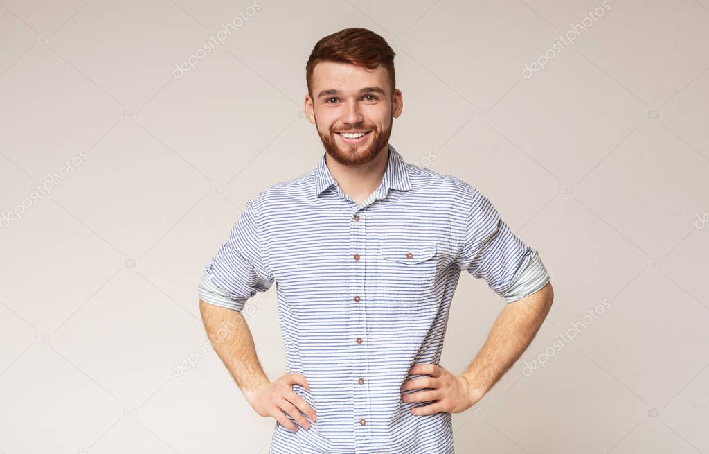 Portrait of smiling guy with hands on hips