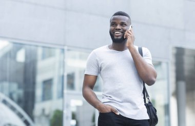 Genç Afrikalı adam arkadaşı yla telefonda konuşuyor ve gülümsüyor