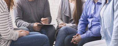 Grup terapisi sırasında hastalarla konuşan panolu danışman