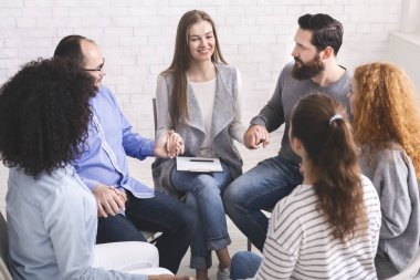 El ele tutuşarak daire içinde sandalyelerde oturan farklı insanlar