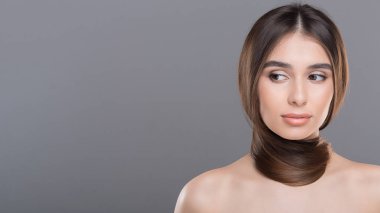 Eşarp gibi boyun etrafında uzun sağlıklı saçları ile genç kadın