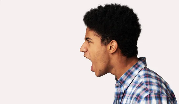 Furioso afro ragazzo gridando su sfondo chiaro — Foto Stock