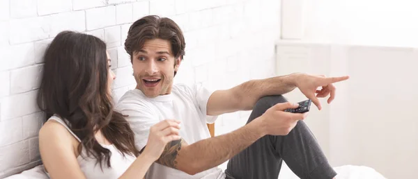 Emocional pareja milenaria viendo la televisión en casa —  Fotos de Stock