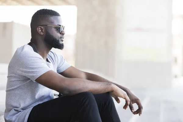 야외에 앉아 선글라스에 자신감 아프리카 사람 — 스톡 사진