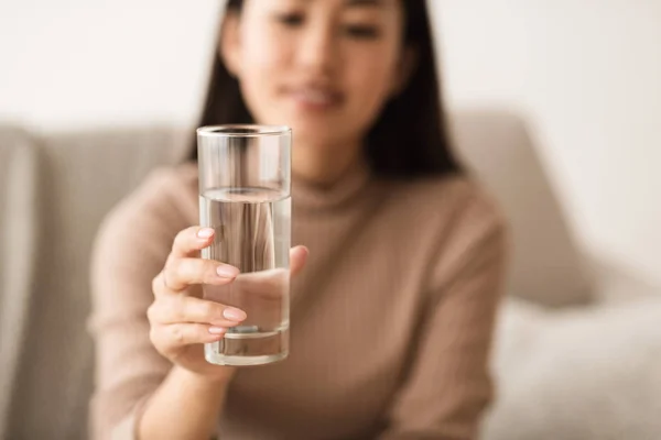 Menina asiática segurando água mineral em vidro — Fotografia de Stock