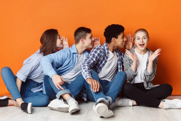 Groep vrienden elkaar in het oor fluisteren — Stockfoto