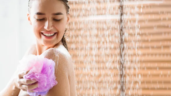 Kobieta tarcie ciała z pianki, ciesząc się orzeźwiający prysznic — Zdjęcie stockowe