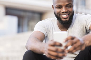 Açık havada cep telefonu kullanan Afrikalı adamın portresini kapatın