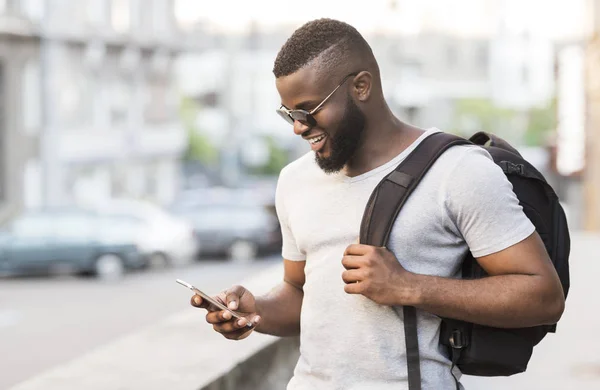 Щасливий африканський хлопець спілкується з друзями на мобільному телефоні — стокове фото