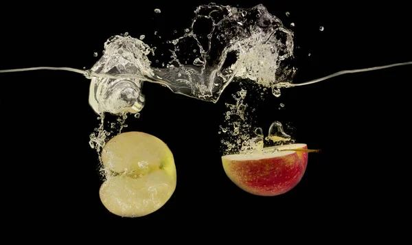 Спелые красное яблоко половинки брызг в чистой воде — стоковое фото