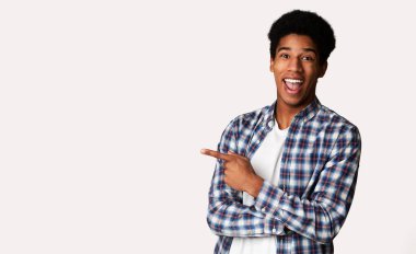 Excited Black Millennial Guy Pointing Away at Free Space clipart