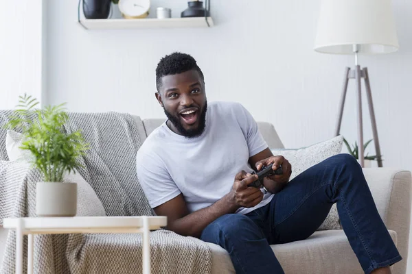 Молодой человек играет в видеоигры дома — стоковое фото