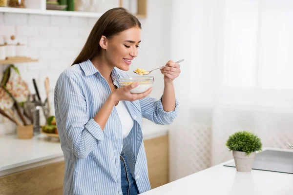 Zdrowe śniadanie. Kobieta jedzenia płatków kukurydzianych z jogurtem — Zdjęcie stockowe