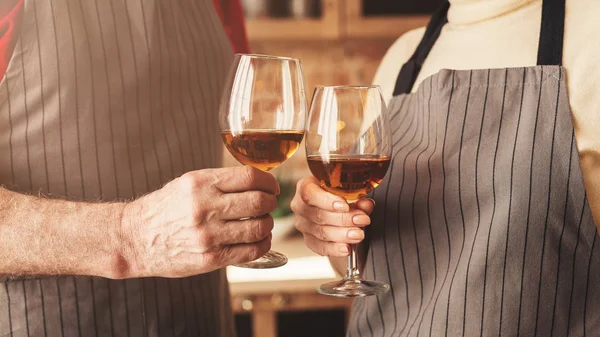 Casal sênior clinking com copos de vinho na cozinha — Fotografia de Stock