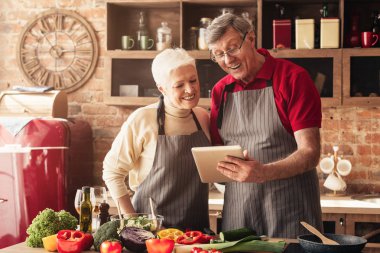 Mutfakta dijital tablet üzerinde Kıdemli çift okuma tarifi