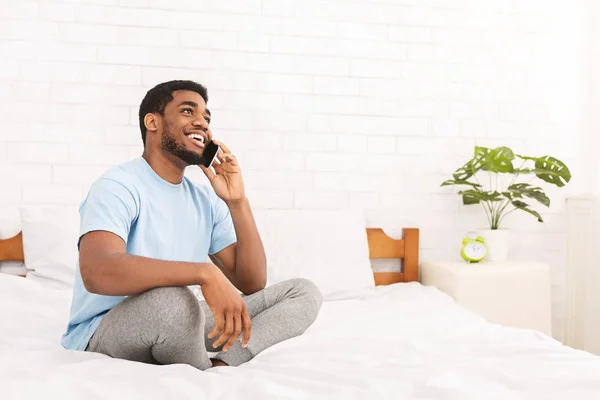 Vesel afro-american tip vorbind la telefon în pat — Fotografie, imagine de stoc