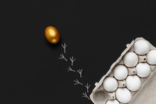 白い卵のグループを分離する1つの金の卵、黒い背景 — ストック写真