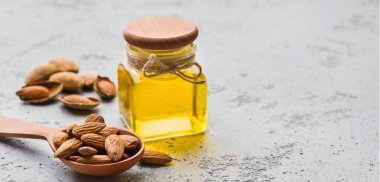 Badem yağı ve badem ile tahta kaşık Şişe