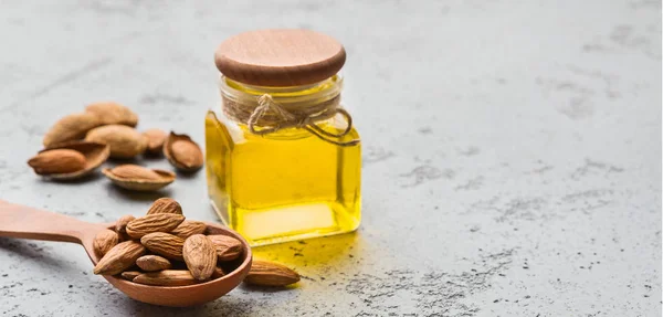 Flasche Mandelöl und Holzlöffel mit Mandeln — Stockfoto