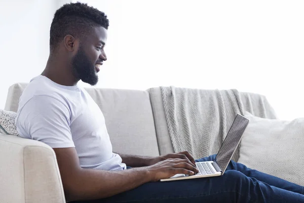 Millennial homem negro trabalhando no laptop no escritório em casa — Fotografia de Stock