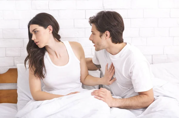 Annoyed woman refusing man in bed because of hangover — Stock Photo, Image