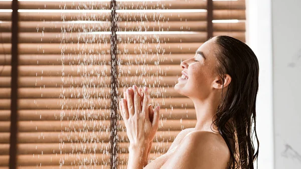 Mujer tomando ducha disfrutando de agua salpicando en su —  Fotos de Stock