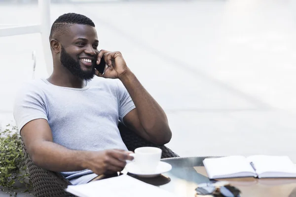 Νέος Αφρικανός επιχειρηματίας που χαλαρώνει σε ένα καφέ και χαμογελάει — Φωτογραφία Αρχείου
