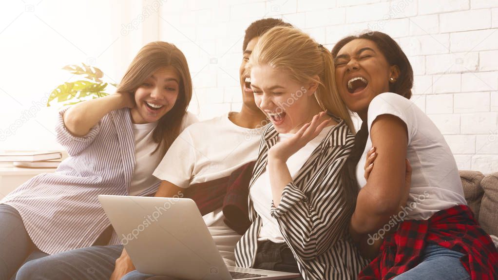 Teen friends watching funny video on laptop