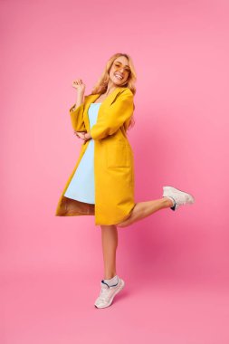 Pozitif Bin yıllık kız atlama ve Pembe Arka Plan üzerinde Poz